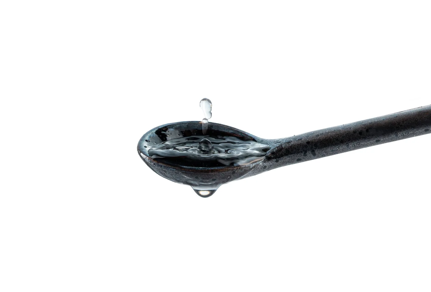 Spoonful of the seven-ingredient Micro Glow formula beside fresh botanicals